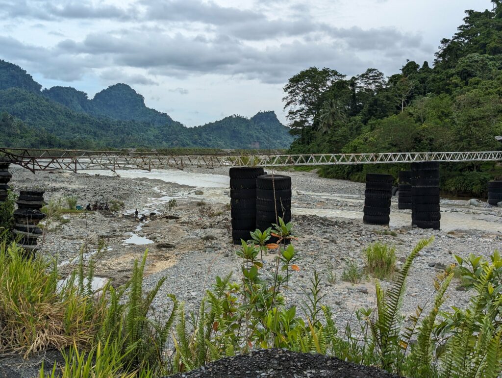 A "bridge" constructed by BCL for people to cross the river. Locals removed the mesh floor in an effort to prevent it from being used due to its poor safety.